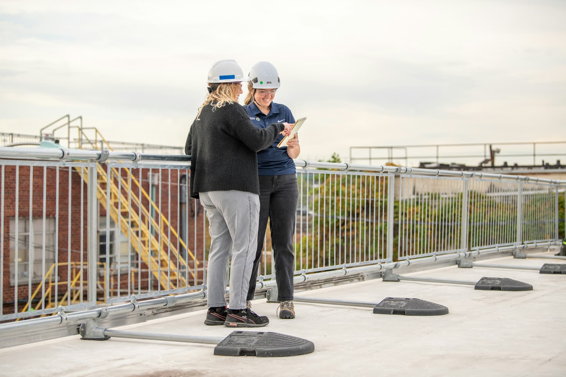 Two people reviewing documents on a commercial building rooftop