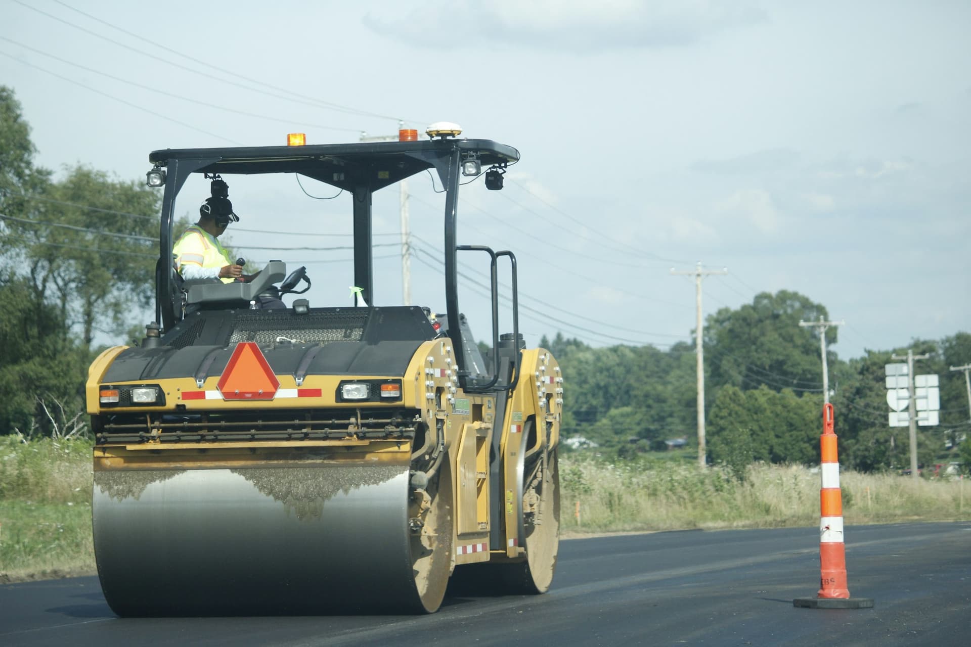 Asphalt roller compacting a freshly paved surface