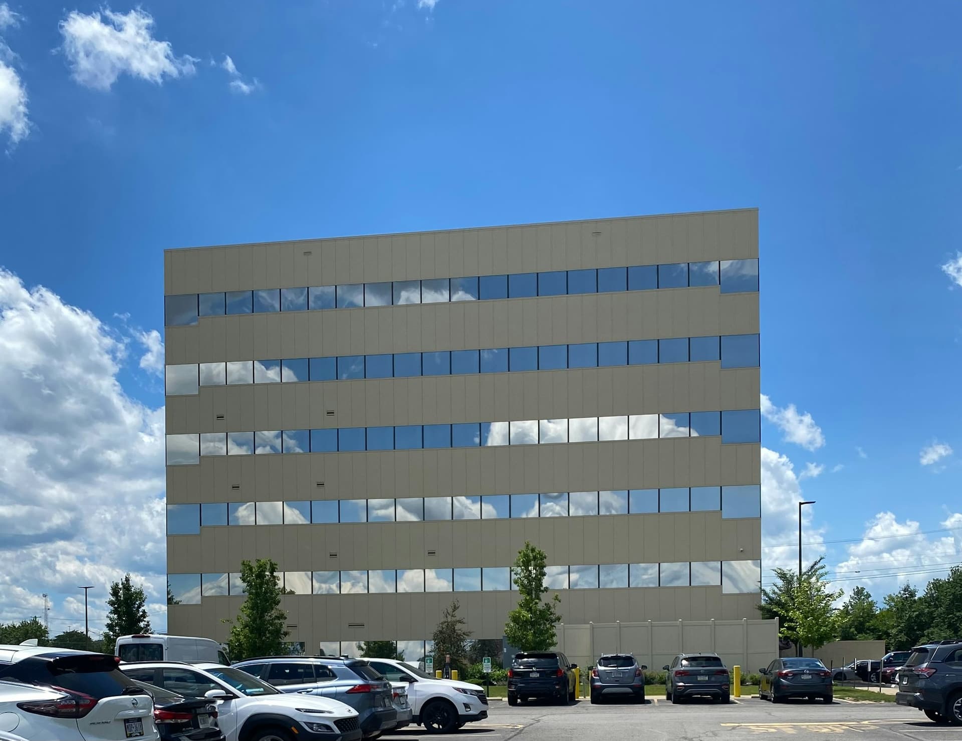Mid-rise office building with reflective glass and a parking lot