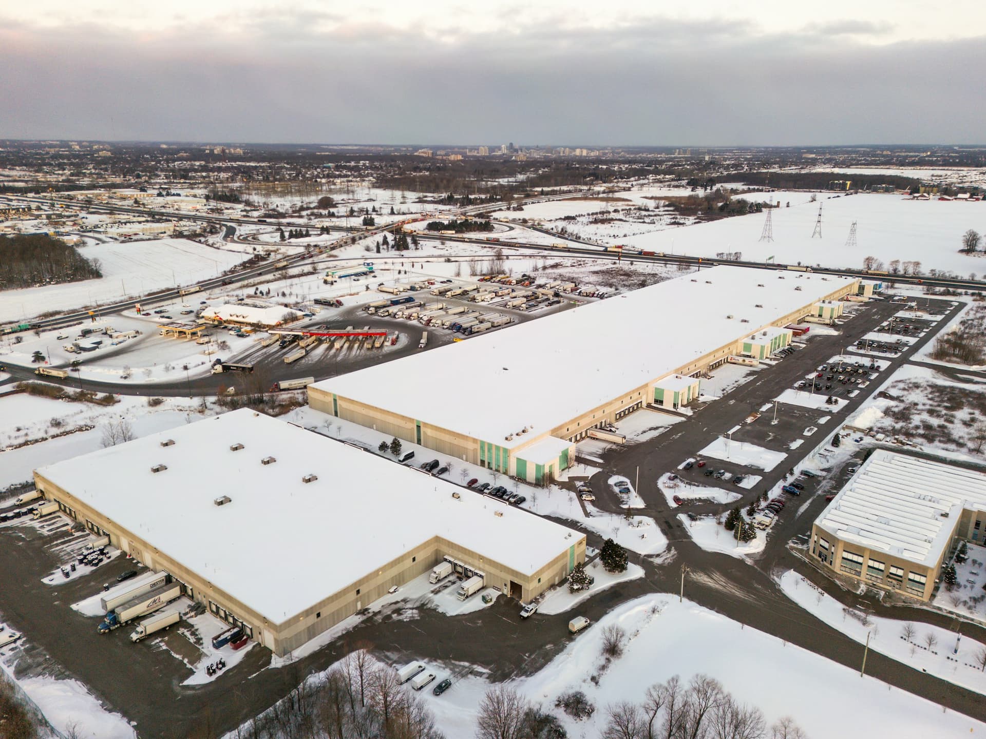 Aerial view of an industrial park with snow-covered roofs and plowed lots